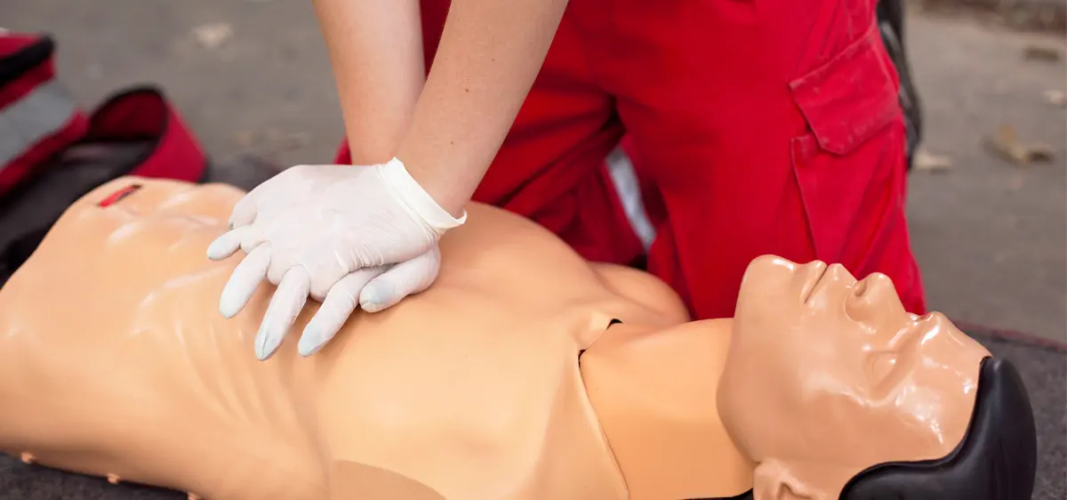 Participant réalisant un massage cardiaque sur mannequin lors d'une formation aux premiers secours.